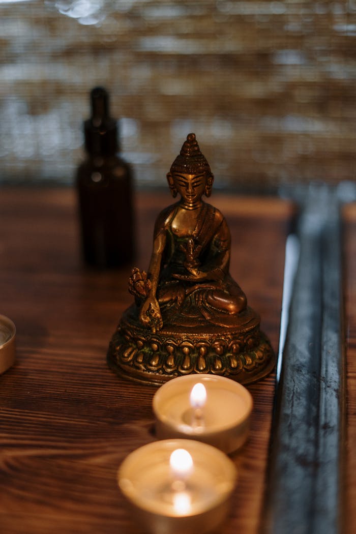 Buddha statue with candles creating a serene spa atmosphere, ideal for relaxation and mindfulness.