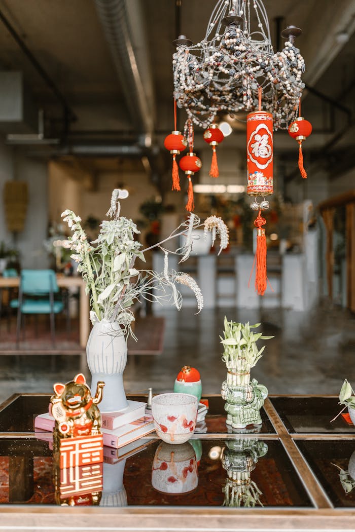 Elegant Chinese New Year decorations with vibrant red lanterns and cultural symbols on a reflective surface.
